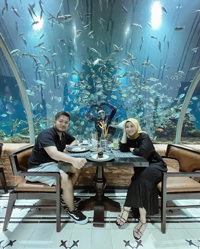 Kebahagiaan mereka amat terpancar saat makan berdua dengan background aquarium raksasa. (foto: instagram.com/kesharatuliu05)