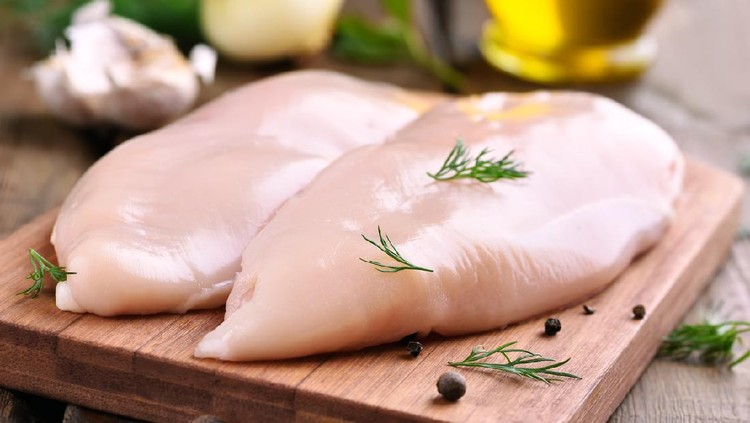 Dada Ayam Raw chicken breasts and spices on wooden cutting board, close up view