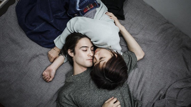 Pasutri Young Couple Lying down on a bed, holding each other