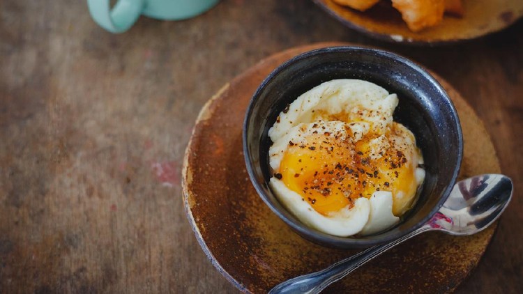 Soft-boiled eggs on color wooden background