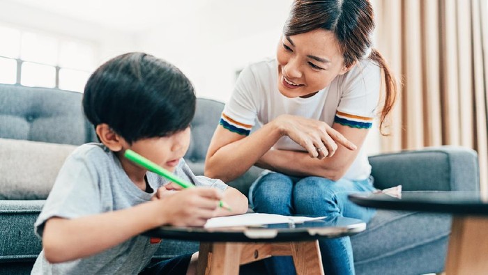 Young mother teaching her son