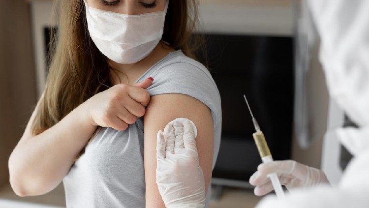 Doctor in personal protective suit or PPE inject vaccine shot to stimulating immunity of woman patient at risk of coronavirus infection. Coronavirus,covid-19 and vaccination concept.