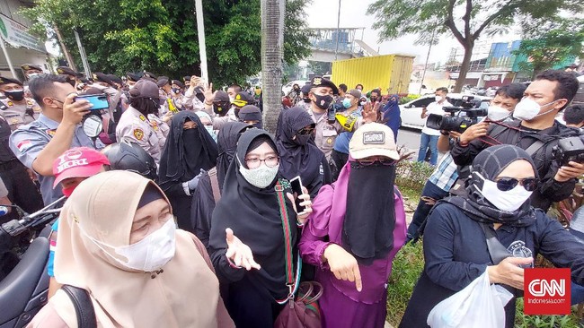 Polisi membubarkan paksa massa yang sebagian besar ibu-ibu untuk mendukung mantan Imam Besar FPI Rizieq Shihab di Pengadilan Negeri Jakarta Timur.