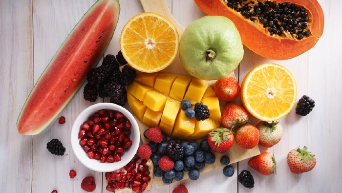 healthy fresh mixed fruits on white wooden table