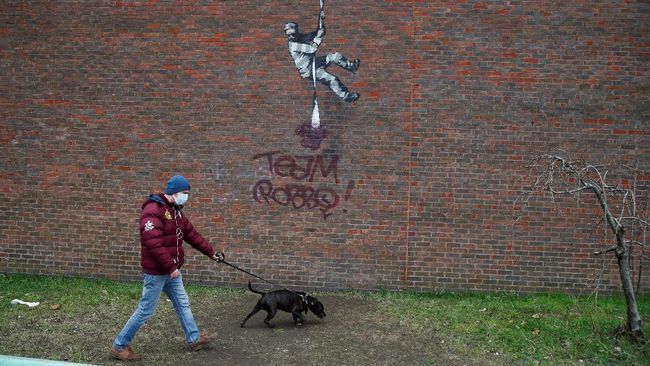 Mural terbaru Banksy di tembok salah satu bekas penjara di Inggris terlihat dicoreti nama rival sesama seniman jalanan yang kini sudah meninggal dunia, Robbo.