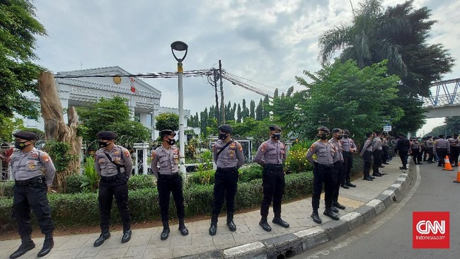 Aparat keamanan membuat barikade untuk menutup akses masuk ke PN Jaktim dan mengingatkan massa pendukung Rizieq Shihab agar tak membuat kerumunan.