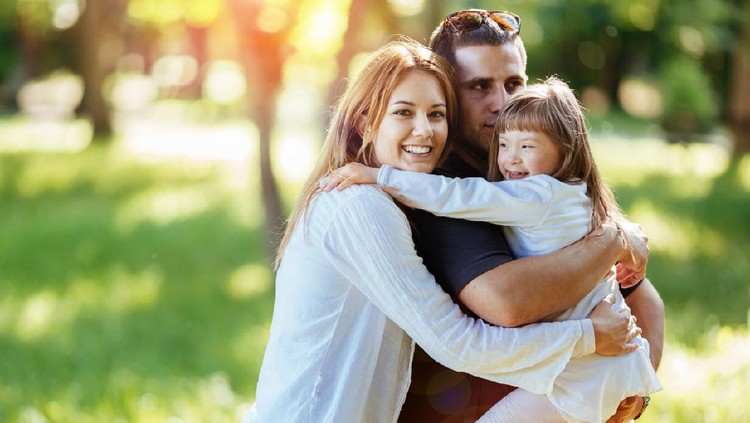 540124462 Family happy outdoors with adopted child born with down syndrome