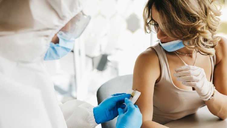 The doctor gives the vaccine against covid19 virus to a female patient