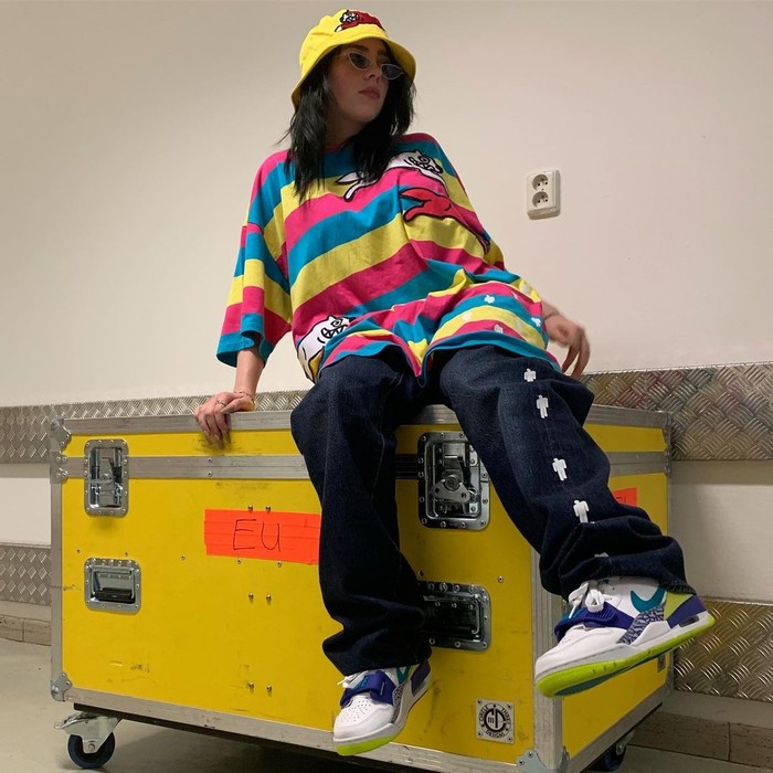 Billie Eilish tahu bagaimana memainkan warna pada outfitnya. Saat turnya, adik dari Finneas O’Connell ini mengenakan pakaian yang menampilkan atasan bergaris, jeans longgar, dan aksesori unik. (foto: instagram.com/billieeilish)