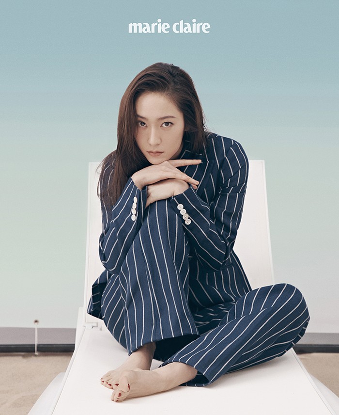 Dengan duduk di atas kursi santai, Krystal berpose menatap kamera dan memakai setelan blazer linen dan celana garis berwarna navy. (Foto: marieclairekorea.com)