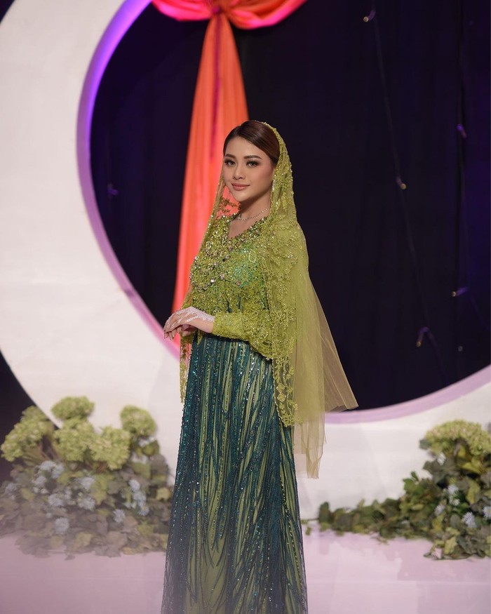 Aurel mengenakan dress brokat bertabur payet kombinasi warna lime green dan hijau emerald. Rancangan Asky Febrianty itu membuat Aurel sangat anggun. Kerudung berbahan lace semakin menyempurnakan tampilan Aurel.(Foto: instagram.com/aurelie.hermansyah)