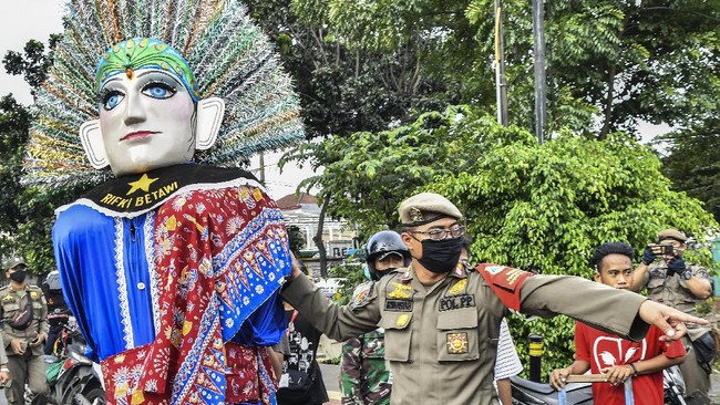 Seorang remaja berkaos sebuah sanggar betawi yang mengarak ondel-ondel di jalanan menjadi salah satu yang terjaring operasi Satpol PP Jaktim, Rabu (23/3).