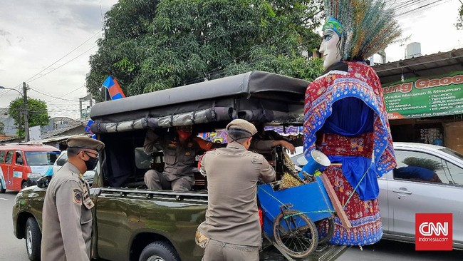 Seorang remaja berkaos sebuah sanggar betawi yang mengarak ondel-ondel di jalanan menjadi salah satu yang terjaring operasi Satpol PP Jaktim, Rabu (23/3).