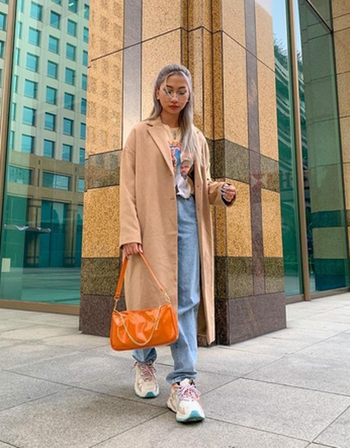 Di sini, gaya streetstyle Dillah tampak lebih mature dengan pemakaian long coat berwarna cokelat ini. Pemakaian handbag oranye dan sneakers putih membuatnya terlihat menawan. (foto: instagram.com/dillaprb)