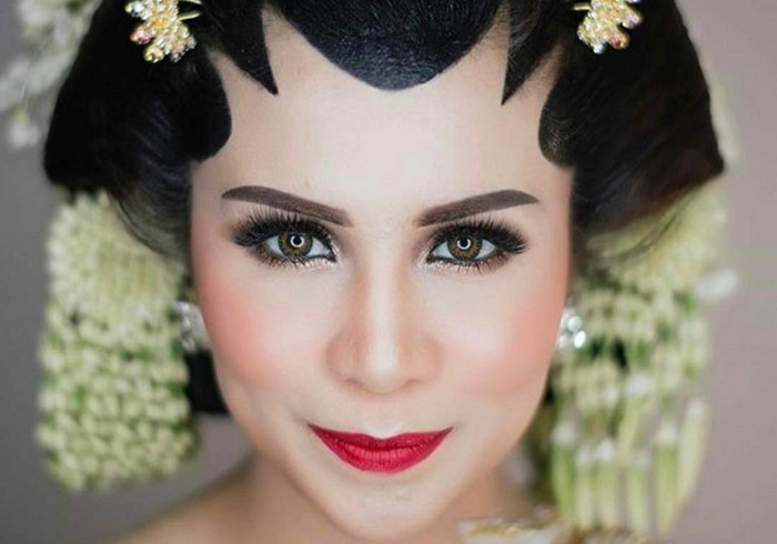 Momo Geisha menampilkan kesan yang glamour untuk makeup pengantin Jawa-nya. Riasan mata bernuansa smoke eyes terlihat lebih dramatis. Semakin lengkap dengan pilihan lipstik merah yang begitu indah. (Foto: instagram.com/therealmomogeisha)