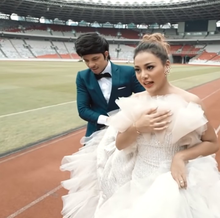 <p>Karena terlalu berat, Atta beberapa kali harus membantu Aurel mengangkat gaunnya saat jalan bersama. (Foto: YouTube: Atta Halilintar)</p>