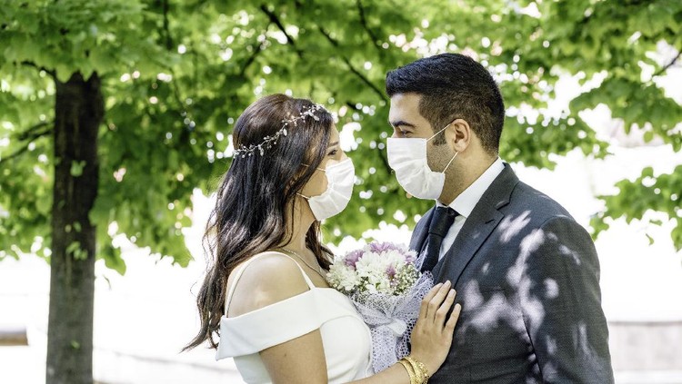 1227435116 bride and groom in a face protection mask