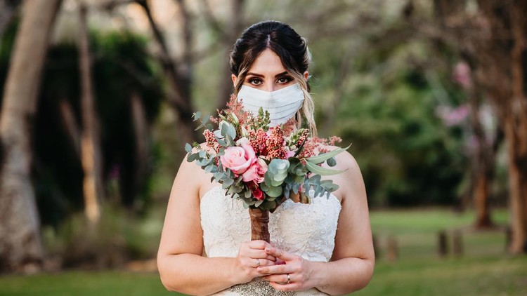 1227435116 bride and groom in a face protection mask