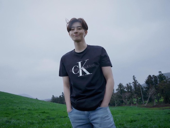 Paduan kaos hitam dari Calvin Klein serta celana jeans berwarna cerah ini juga membuat tampilan Park Seo Joon terlihat lebih santai dan lebih kece, nih! (Foto: instagram.com/dazedkorea)