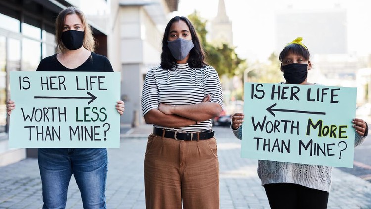 A man holding Racism is a Virus sign