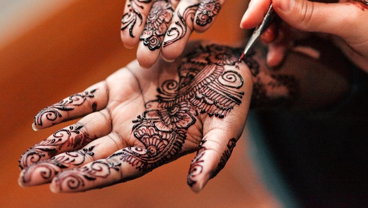 Cropped shot of an unrecognizable woman getting henna applied to her hands in preparation for her wedding