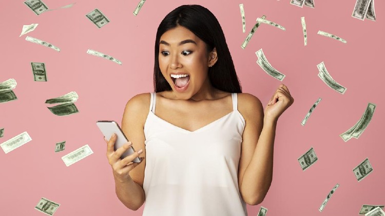 Ilustrasi uang Big Win. Creative Collage Of Asian Girl With Smartphone In Hands Celebrating Victory Under Money Shower Of Dollar Banknotes