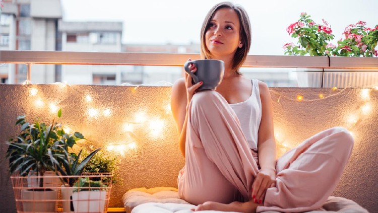 Ilustrasi Balkon Minimalis Women enjoy her special moment on terrace. She holding cup and sitting on pallet.