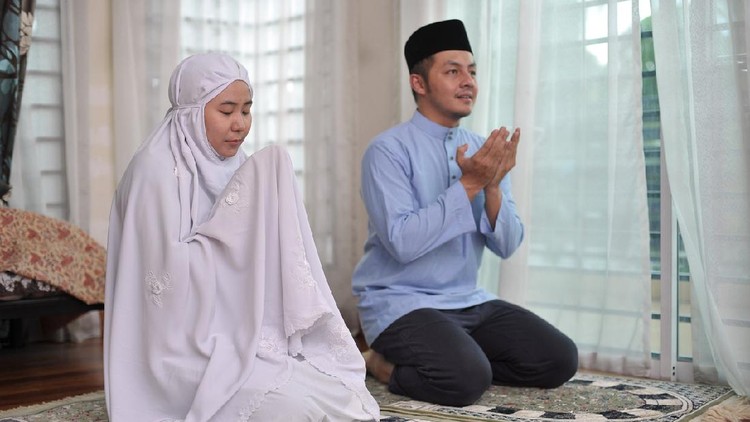 Asian family praying together during ramadhan