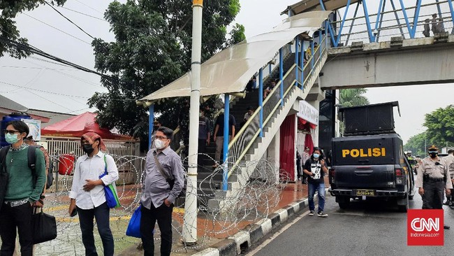 Polisi memasang kawat barikade untuk mengamankan sidang Rizieq Shihab di PN Jakarta Timur, Selasa (30/3).