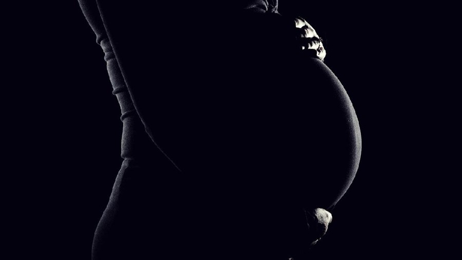 Low key portrait of a young woman's pregnant belly.Image is processed from a 16 bit RAW file and profiled in ProPhoto RGB. All my images are professionally retouched.More from this Series: