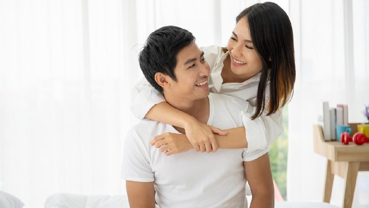 1225493996 Beautiful Asian couple laying and talking together on the bed. Couple relationship concept.