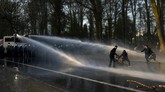 FOTO: Polisi Bubarkan Massa Konser Palsu 'April Mop' Belgia Polisi semprotkan water cannon ke ribuan orang yang berkumpul di taman Brussel untuk menyaksikan konser palsu yang diumumkan di medsos.