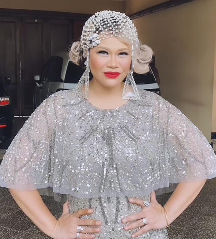 Okky Lukman hadir tak hanya sebagai tamu kondangan tapi juga presenter di momen resepsi Aurel-Atta dengan memakai dress dan aksesoris bernuansa perak/Sumber/Instagram/okkydatanglagi.