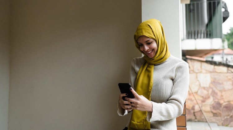 Ilustrasi Berkirim Pesan Ramadhan Young woman, cloth on her head, on the phone, working, looking at Ramadan, religious dress