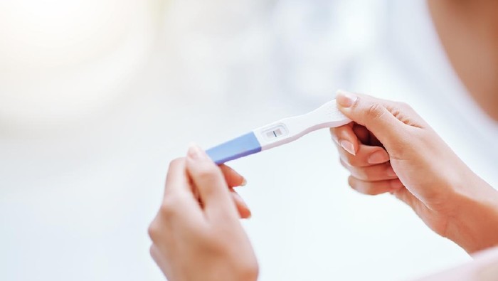 Cropped shot of a young woman taking a pregnancy test
