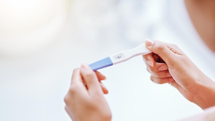 alat tes kehamilan Cropped shot of a young woman taking a pregnancy test