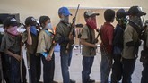 FOTO: Anak Meksiko Siap 'Angkat Senjata' Lawan Kartel Narkoba Sekelompok anak di salah satu desa di Meksiko berbaris membawa replika senjata sebagai latihan untuk menghadapi kartel narkoba yang kian meresahkan.