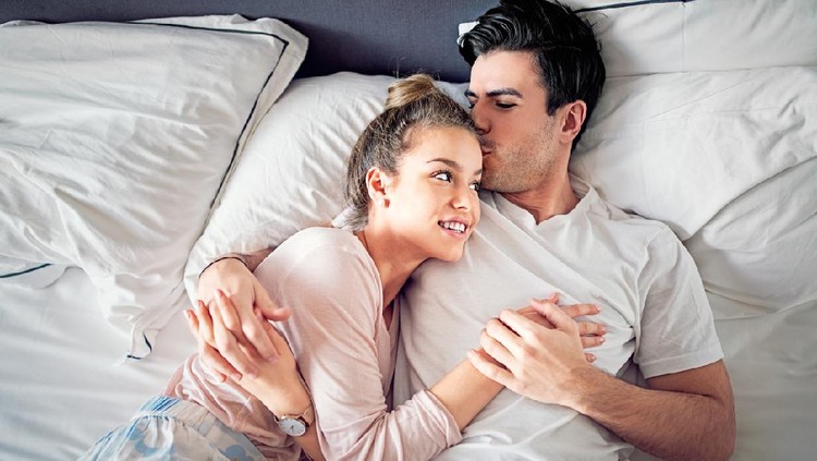 Ilustrasi Posisi Seks Couple is kissing and hugging in bed