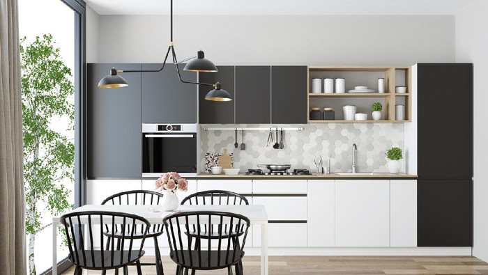 Trendy Scandinavian open concept kitchen and dining room with lots of natural light.
Functional, modern and bright one wall kitchen with gray and white wooden cabinets, 
open light wood shelves and light gray honeycomb ceramic back-splash tiles. 
Wooden white dining table and black wooden retro chairs are placed next to a big panoramic window. 
Vintage, big, black metal lighting fixture, wall clock and black and white picture are decorative elements.
Hardwood flooring.