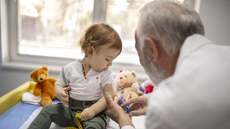 vaksin anak Female nurse gives vaccination to little girl.