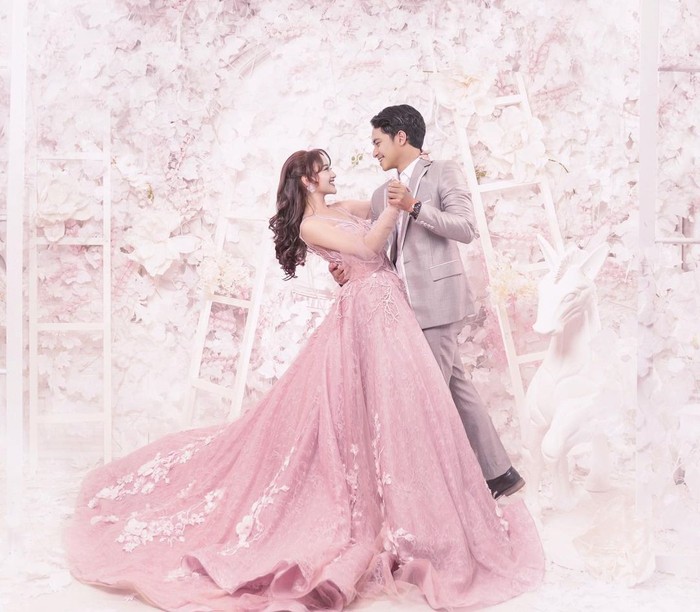 Keduanya tampak berdansa di salah satu shoot prewedding. Layaknya pangeran dan princess, hasil foto yang ditampilkan sangat memikat. Bunga-bunga pink yang dijadikan latar seakan menjadi lambang cinta yang mekar. (Foto: instagram.com/nandaarsynt)