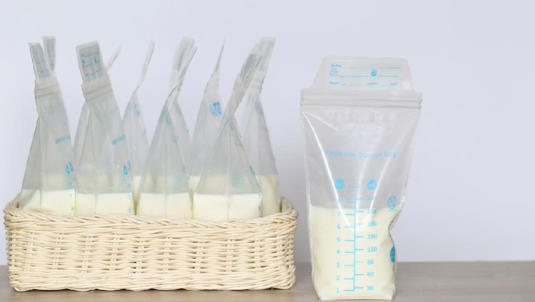 frozen breast milk storage bags for new baby on wooden table