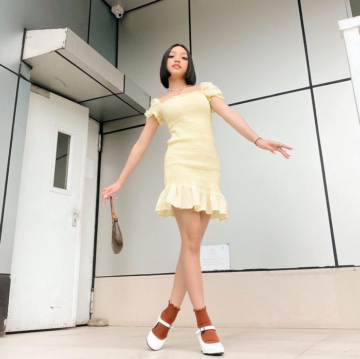 Gadir berusia 15 tahun ini memadukan dress fit body model rample pada bagian ujung lengan dan roknya, dengan high heels. Menariknya, Naura membuat tampilannya lebih manis dengan penambahan kaos kaki/Sumber/Instagram/naura.ayu.