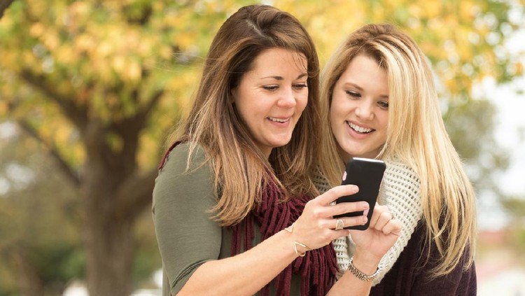 494572046 Mother and daughter shopping on their mobile phone.