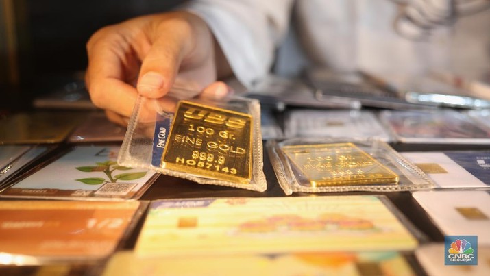 Pegawai merapikan emas batangan di Galeri 24 Pegadaian, Jakarta, Kamis (22/4/2021). Harga emas batangan yang dijual Pegadaian mengalami penurunan nyaris di semua jenis dan ukuran /satuan.  (CNBC Indonesia/Tri Susilo)