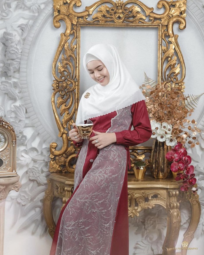 Dalam potret pertama, Amanda tampil memesona dalam balutan gamis berwarna merah dengan detail tulle outer warna putih. Senada dengan itu, hijab putih polos dengan laser cutting ditata menutup dada sehingga tampak lebih sopan. (Foto:instagram.com/fdphotography90)