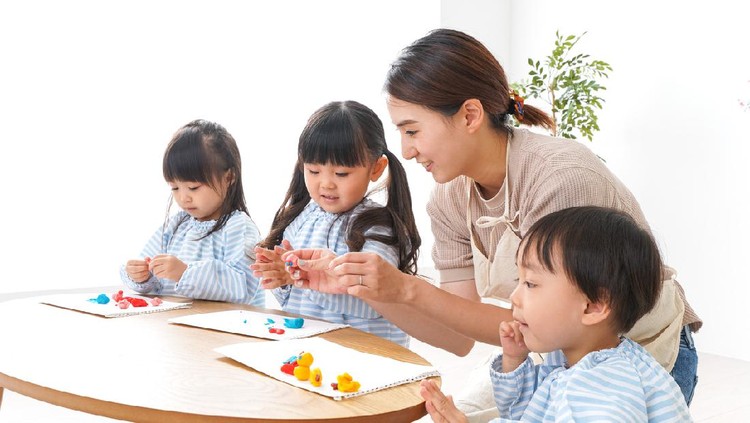 sekolah TK Asian kindergarten student girl with mother painting picture in book with color pencil at home, Homeschooling and distance learning.