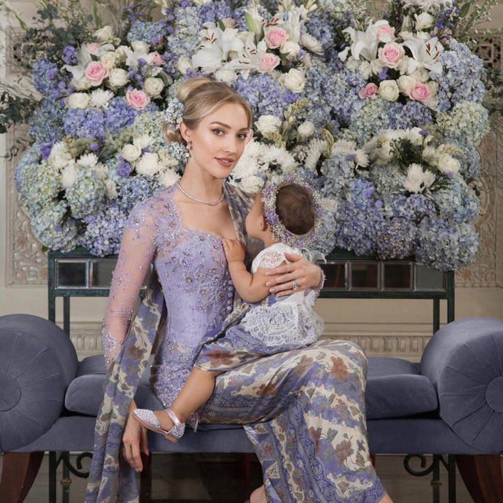 <p>Penampilan istri Panji Adhikumoro, Varsha Strauss sangat anggun berkebaya nih. Wanita keturunan Austria ini tampak luwes memangku anaknya, meskipun tampil dengan batik dan kebaya. Dalam setiap foto anaknya, memang tidak pernah ditampakkan wajahnya, Bunda. (Foto: Instagram @varshaadhikumoro)</p>