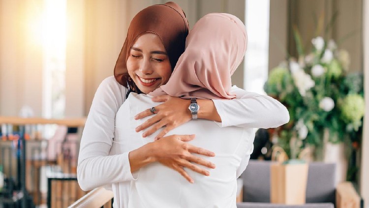 Portrait of young Asian muslim women in happy smile with hijab or head scarf hugs each other indoors. Love and happiness concept