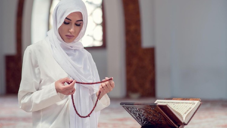 Young beautiful Muslim Woman Praying In Mosque.